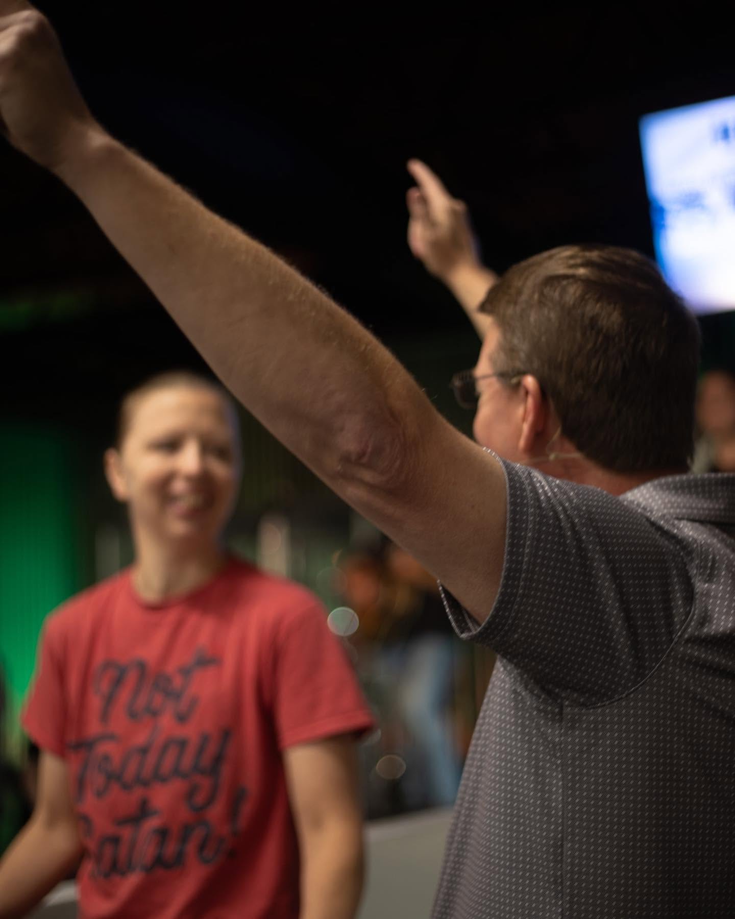 A man worshiping with his hand raised during a Sunday service at Hope House Church